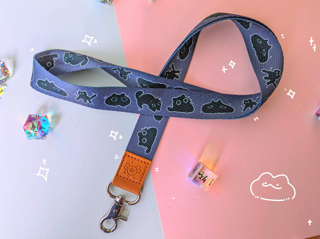 Cute Lanyard with a pattern of void cats or black cats decorating the cloth portion, and a leather stamp of an axolotl.